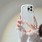 White silicone iPhone case with wavy candy border and raised camera cutouts