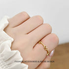 Gold-tone open bow link ring on hand, adjustable fit with chain detail
