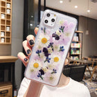 Clear iPhone case with preserved purple flowers, white daisies, and blue accents