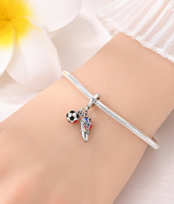 Silver-tone charm bead with soccer ball and player figure on a bracelet bangle