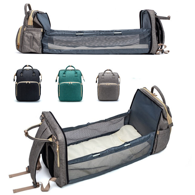 Grey foldable baby travel bed backpack, open interior with side straps and mesh panels.