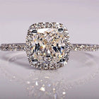 White gold bridal ring set with cushion-cut center stone and pavé halo