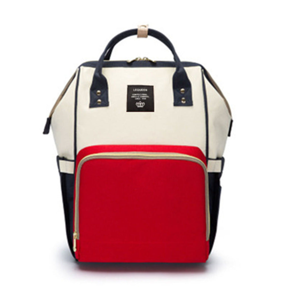 Cream and black maternity diaper bag with red insulated front pocket, top handle and side straps