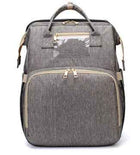 Grey foldable baby travel bed backpack with beige trim, front pocket, and gold hardware