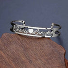 Silver stainless steel cuff bracelet with engraved cursive text and heart-shaped cutout ends