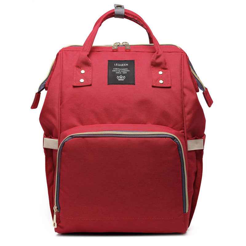 Red maternity diaper bag with front zip pocket and stitched details, top handle and side straps