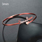 Personalized stainless steel cuff bracelet in rose gold with engraved cursive name and heart charm