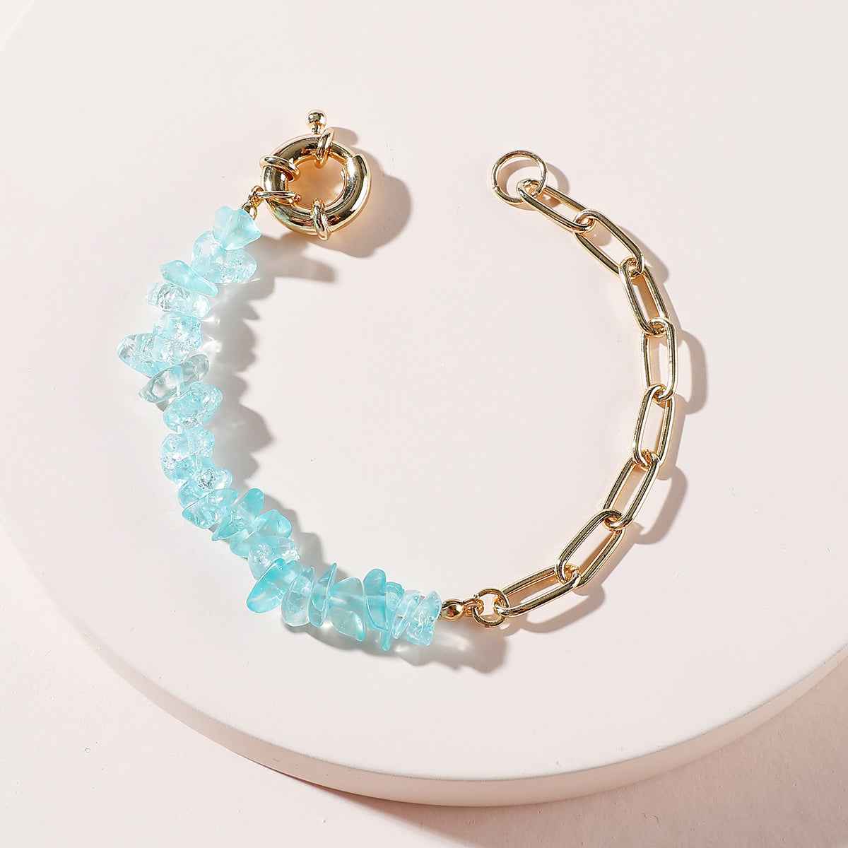 Gold chain bracelet with light blue crystal bead links and spring clasp