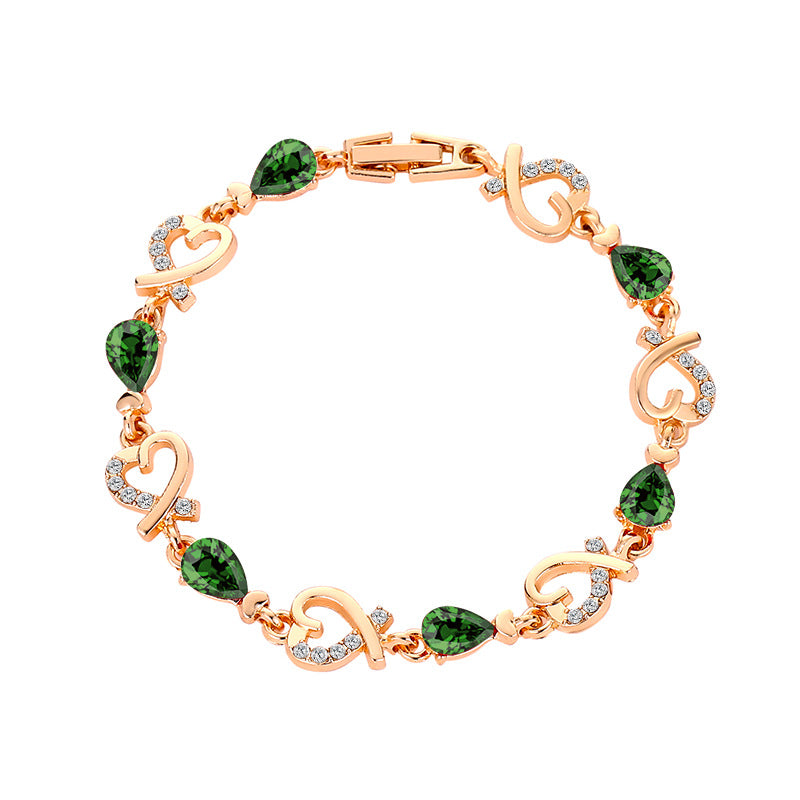 Rhinestone heart charm bracelet with emerald green stones and heart links with crystal accents