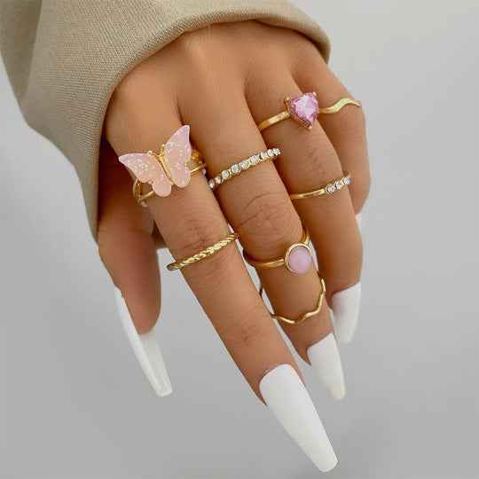 Gold boho stacking rings set with pink butterfly charm and faceted crystal bands
