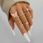 Gold boho stacking rings set with pink butterfly charm and faceted crystal bands