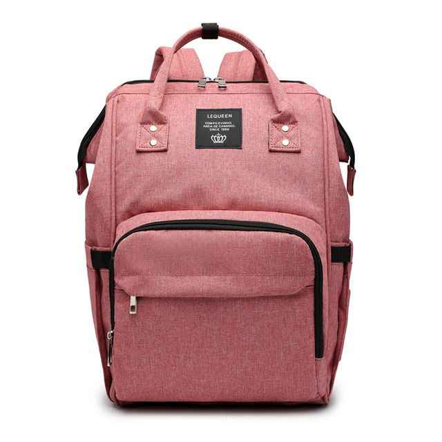 Dusty pink maternity diaper bag with front zip pocket and black trim, top handle and straps