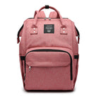 Dusty pink maternity diaper bag with front zip pocket and black trim, top handle and straps