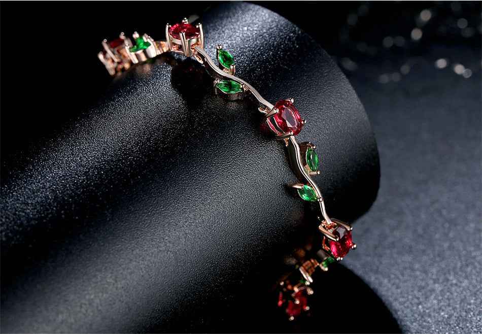 Rose gold crystal cuff bracelet with red and green stones in bezel settings