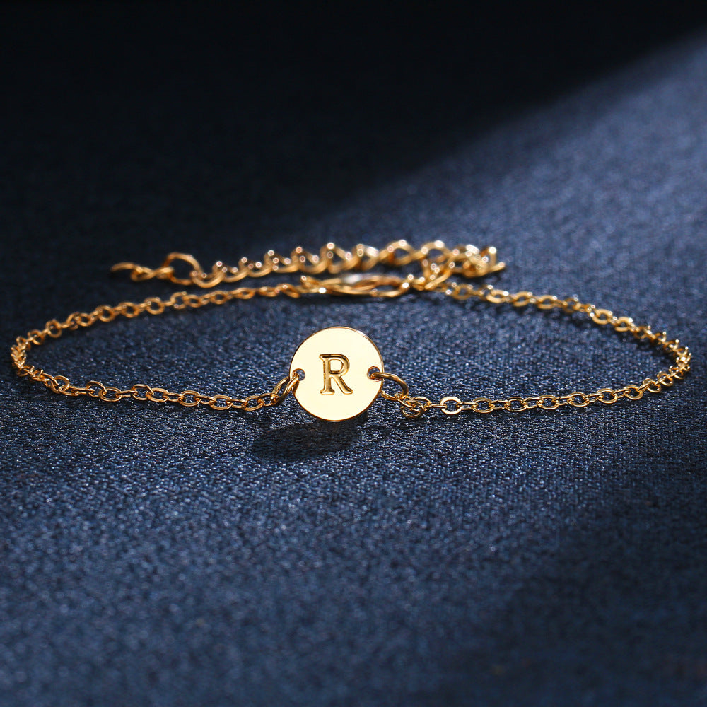 Gold-tone initial bracelet with round charm letter R