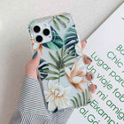 Tropical leaf iPhone phone case with green foliage and orange flowers, clear protective case