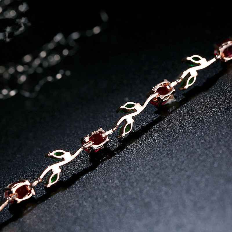 Silver-tone crystal cuff bracelet with red stones and green accents