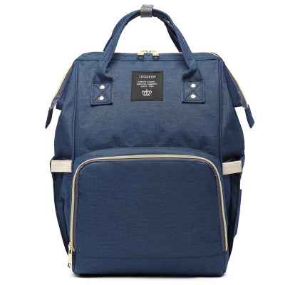 Maternity diaper bag in denim blue with front zipper panel, top handle, and side pockets