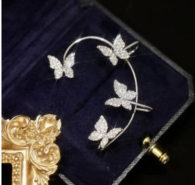 Silver butterfly earrings on a hoop-style frame, with clip backing in a jewelry box