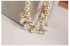 Pearl and gold-tone charm bracelet with stacked pearls, white flower, coin and horse charms