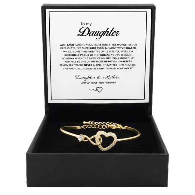 Gold open cuff bracelet with heart charm and crystal-like stone accents