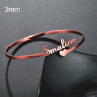 Rose gold 3mm cuff bangle with engraved cursive name and small heart accent