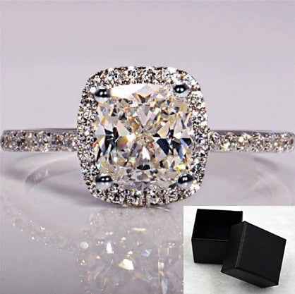 Bridal ring set with cushion-cut clear stone, pavé band, and black box