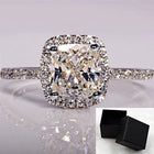Bridal ring set with cushion-cut clear stone, pavé band, and black box