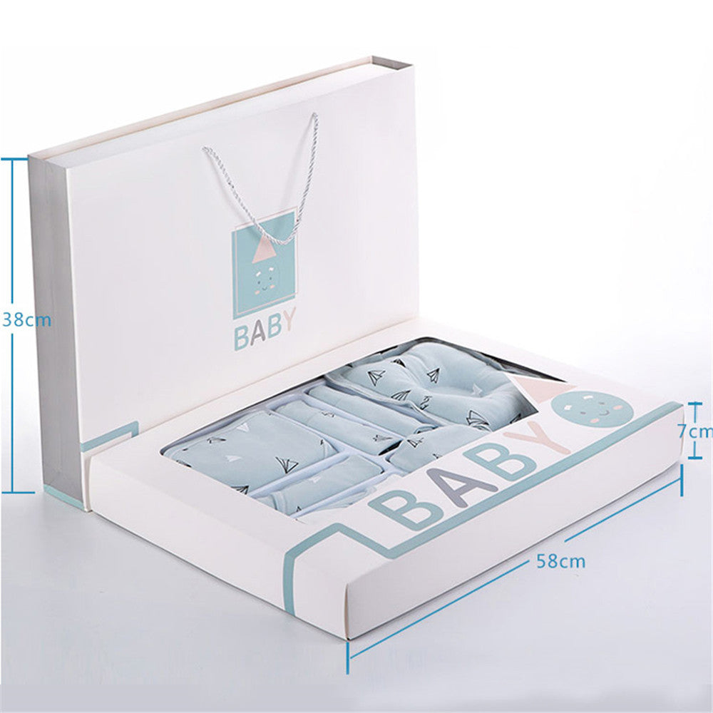 Open baby gift box with light blue baby clothing folded inside, shown in foam tray