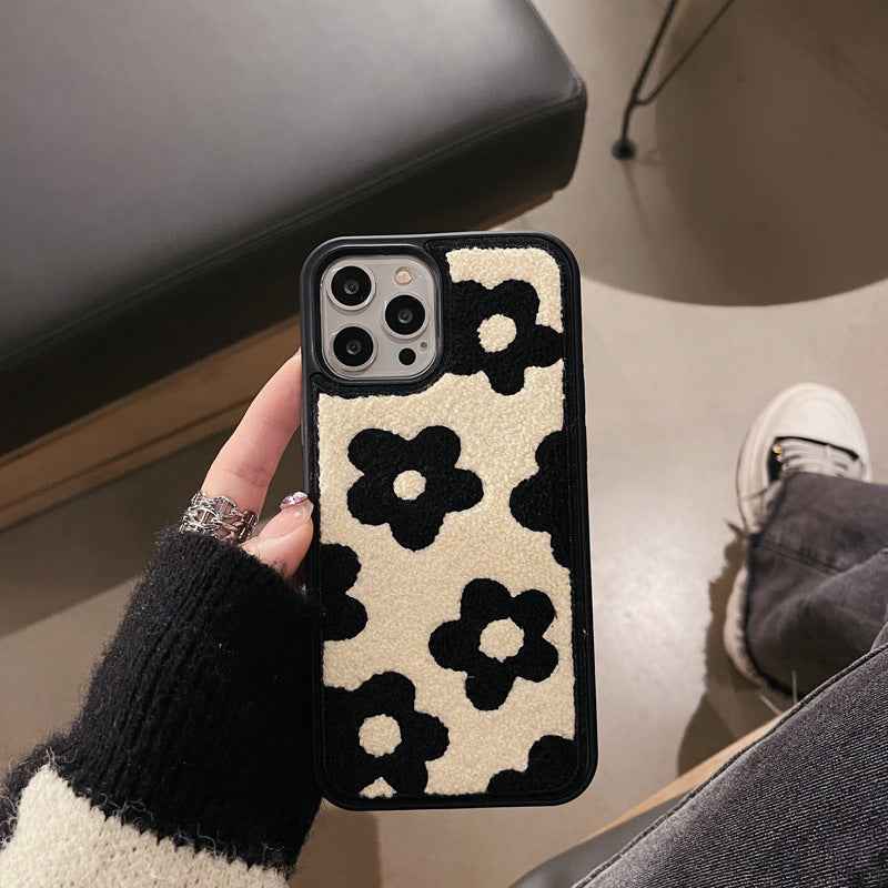 Plush floral iPhone case, cream and black flower pattern; protective raised camera opening
