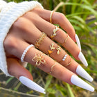 Gold-tone openwork flower rings on hand with pearl and gold bands
