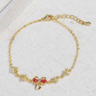 Gold chain bracelet close-up with bow-shaped pink rhinestone center and clasp