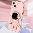 Light pink phone case with 3D astronaut charm, ring grip, and camera cutouts