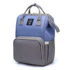 Maternity diaper bag in blue with gray front panel, top handles, and side bottle pockets