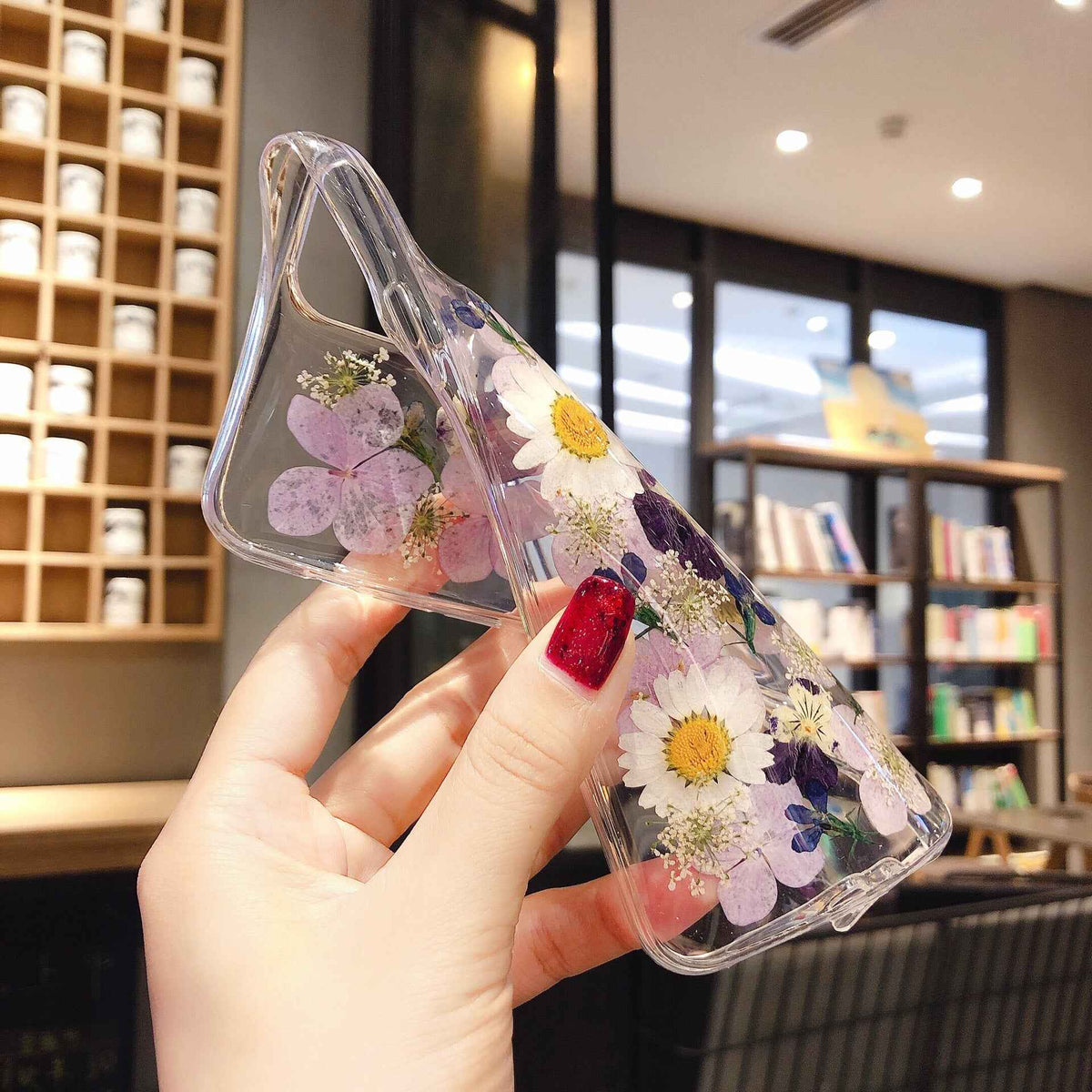 Clear iPhone case with preserved purple and pink flowers and white daisies, side view