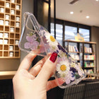 Clear iPhone case with preserved purple and pink flowers and white daisies, side view