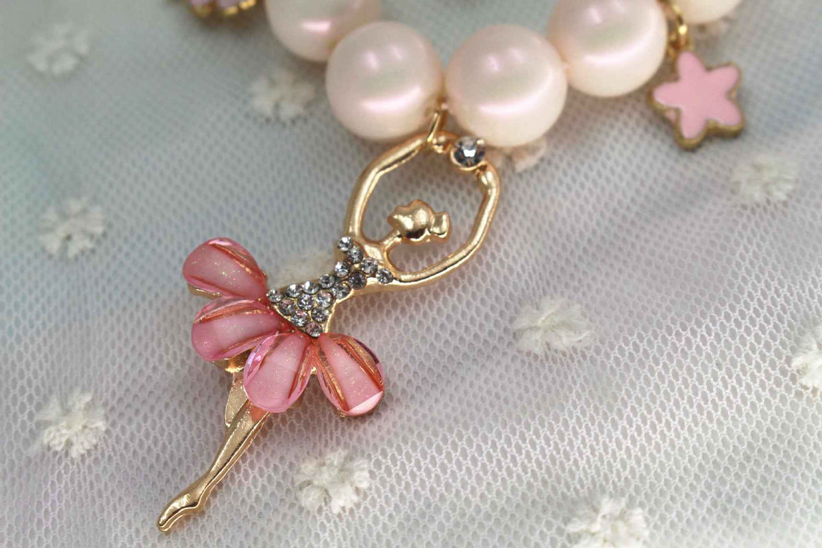 Ballerina charm pendant on pink pearl necklace with bow and gold-tone setting
