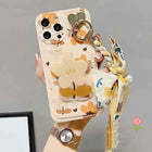 Floral bow phone case with bear-and-flower print, gold ring holder, and ribbon charm