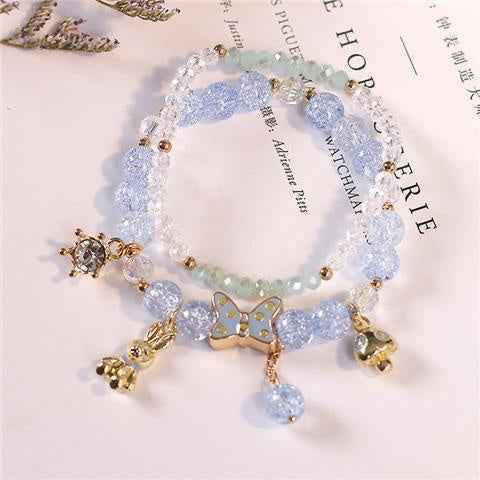 Light blue crystal bracelet with gold-tone cat charm and dangling beads