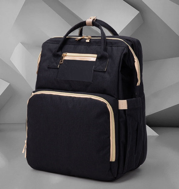 Black foldable baby travel bed backpack with front organizer panel and beige-lined edges
