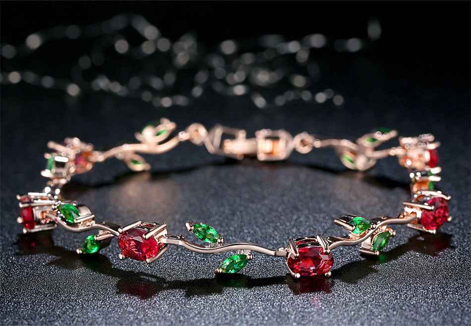 Rose gold crystal cuff with red and green stones and clear accents