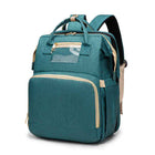 Teal foldable baby travel bed backpack with front organizer pocket and stitched trim.