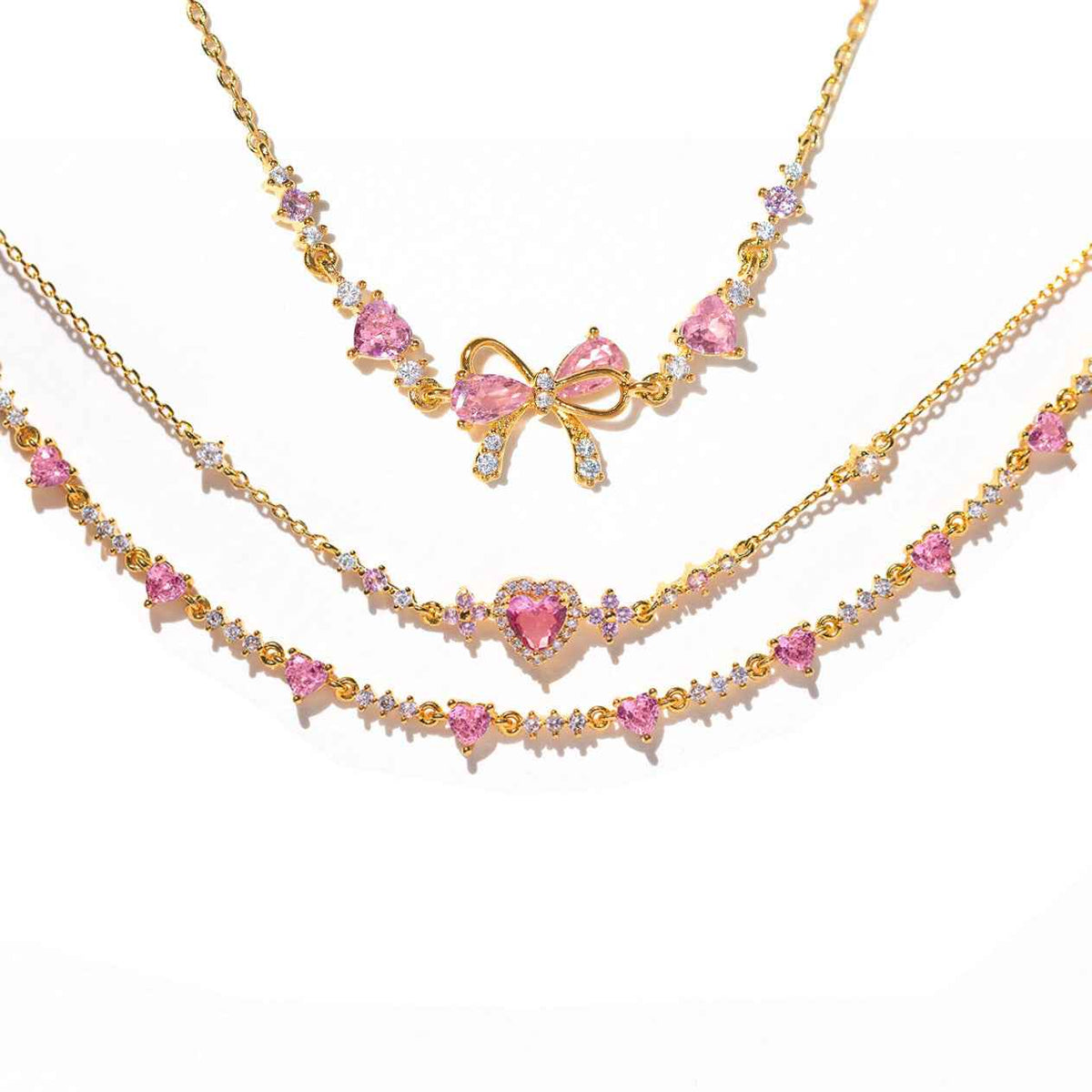 Gold-tone rhinestone bracelet set with pink heart charms and bow centerpiece