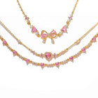 Gold-tone rhinestone bracelet set with pink heart charms and bow centerpiece