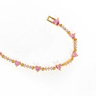 Gold chain bracelet with pink heart charms and rhinestone bow-like detail