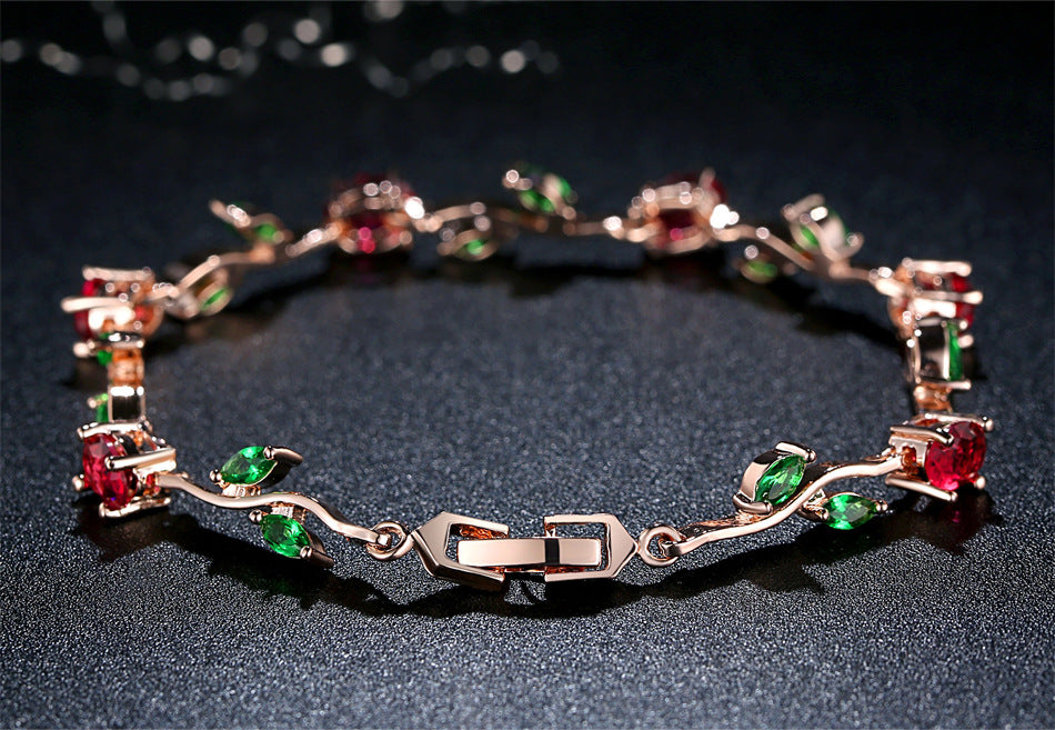 Rose gold crystal cuff with red, green, and clear gemstone settings
