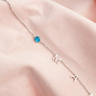 Silver initial necklace with blue round stone and letter charms M A