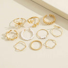 Gold-tone ring set laid out, including openwork flower and pearl bands