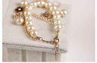 Gold chain bracelet with pearl beads and dangling charm detail