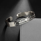 Silver stainless steel cuff bangle with engraved cursive name and open-heart cutout details